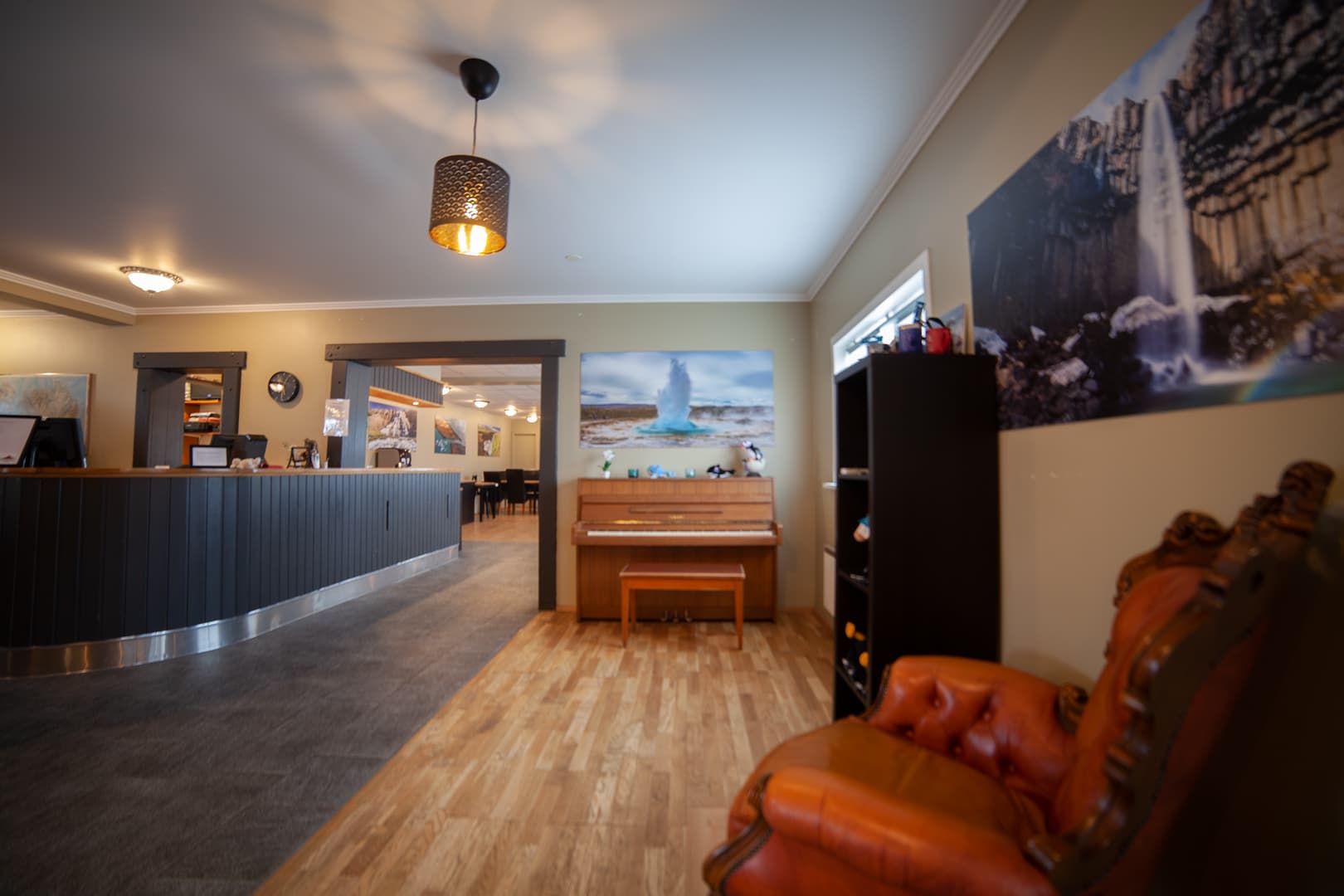 Lounge with a leather armchair, a piano and the reception desk