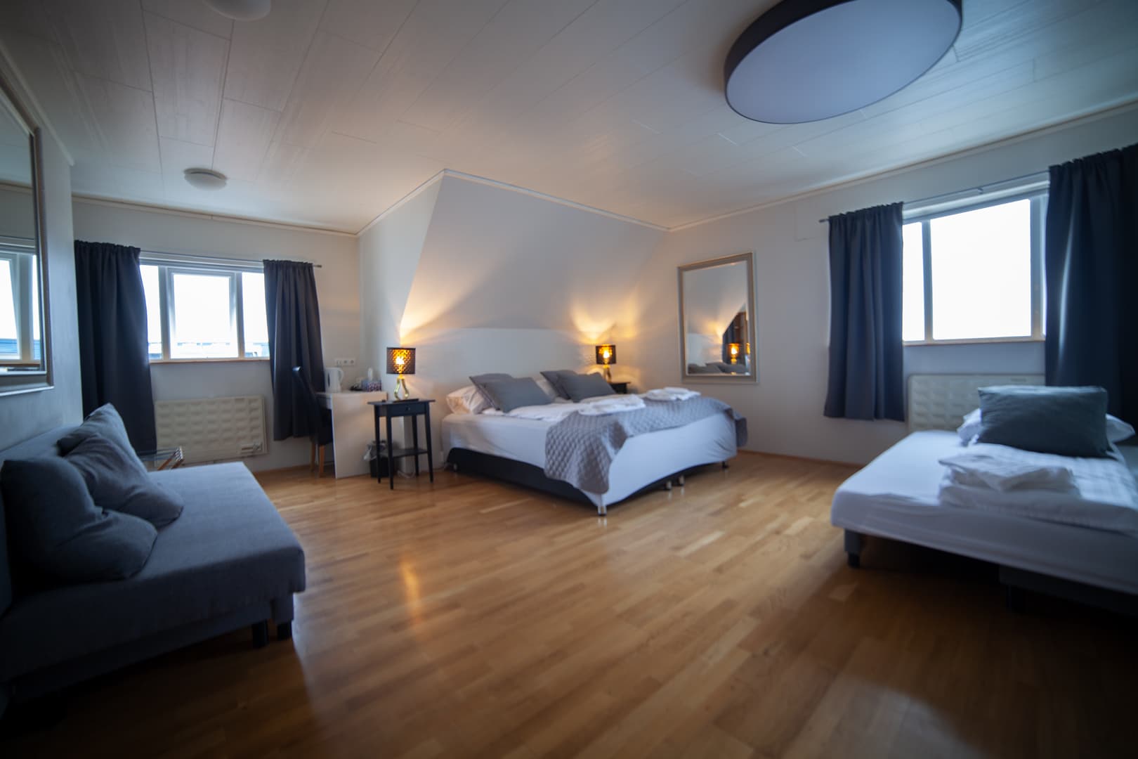 Triple room with a large bed, a single bed and a sofa